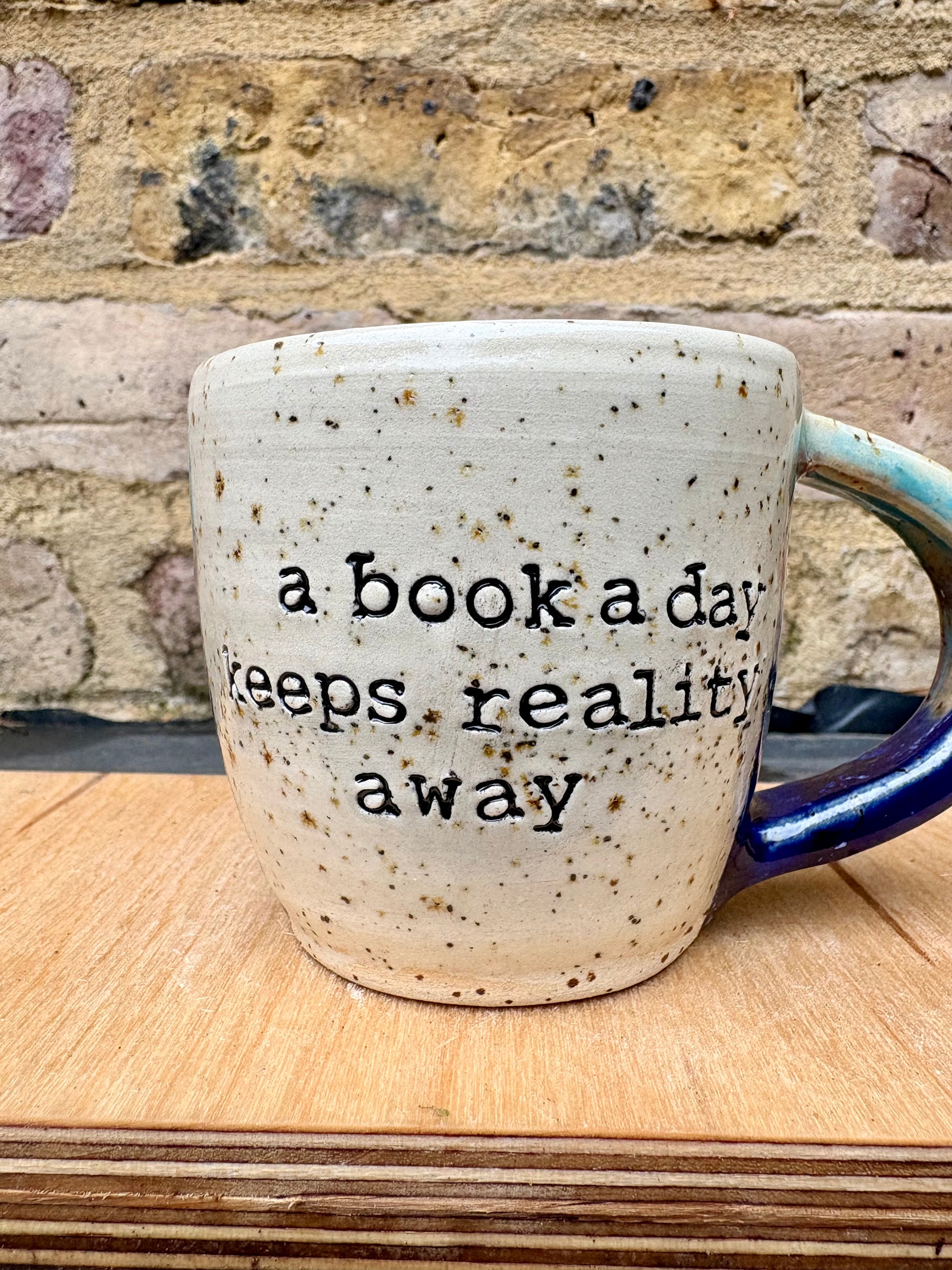 “A book a day keeps reality away" mug (blue night sky)