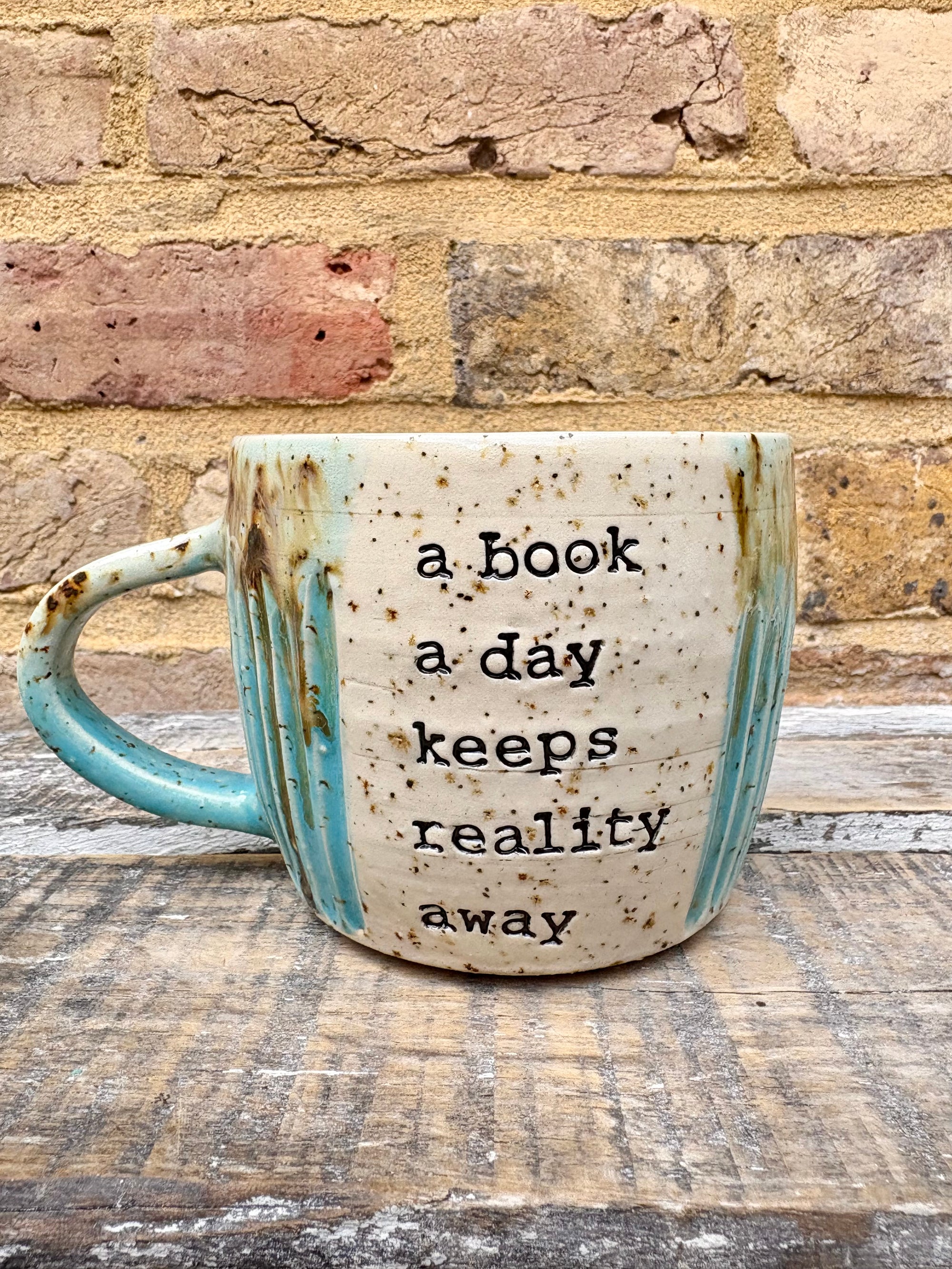 “A book a day keeps reality away" mug (turquoise)