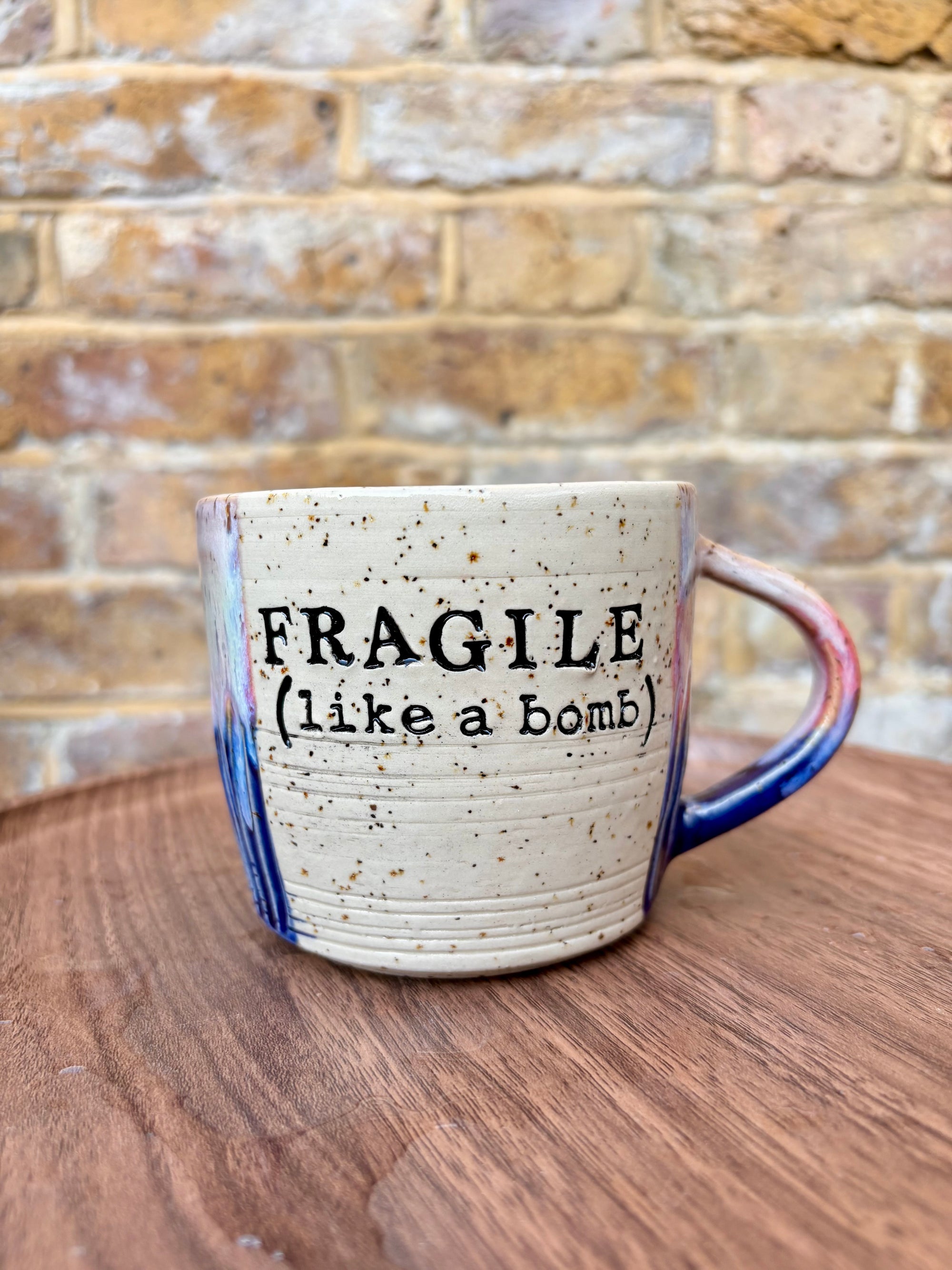 “FRAGILE (like a bomb) mug (blue/pink/black text)