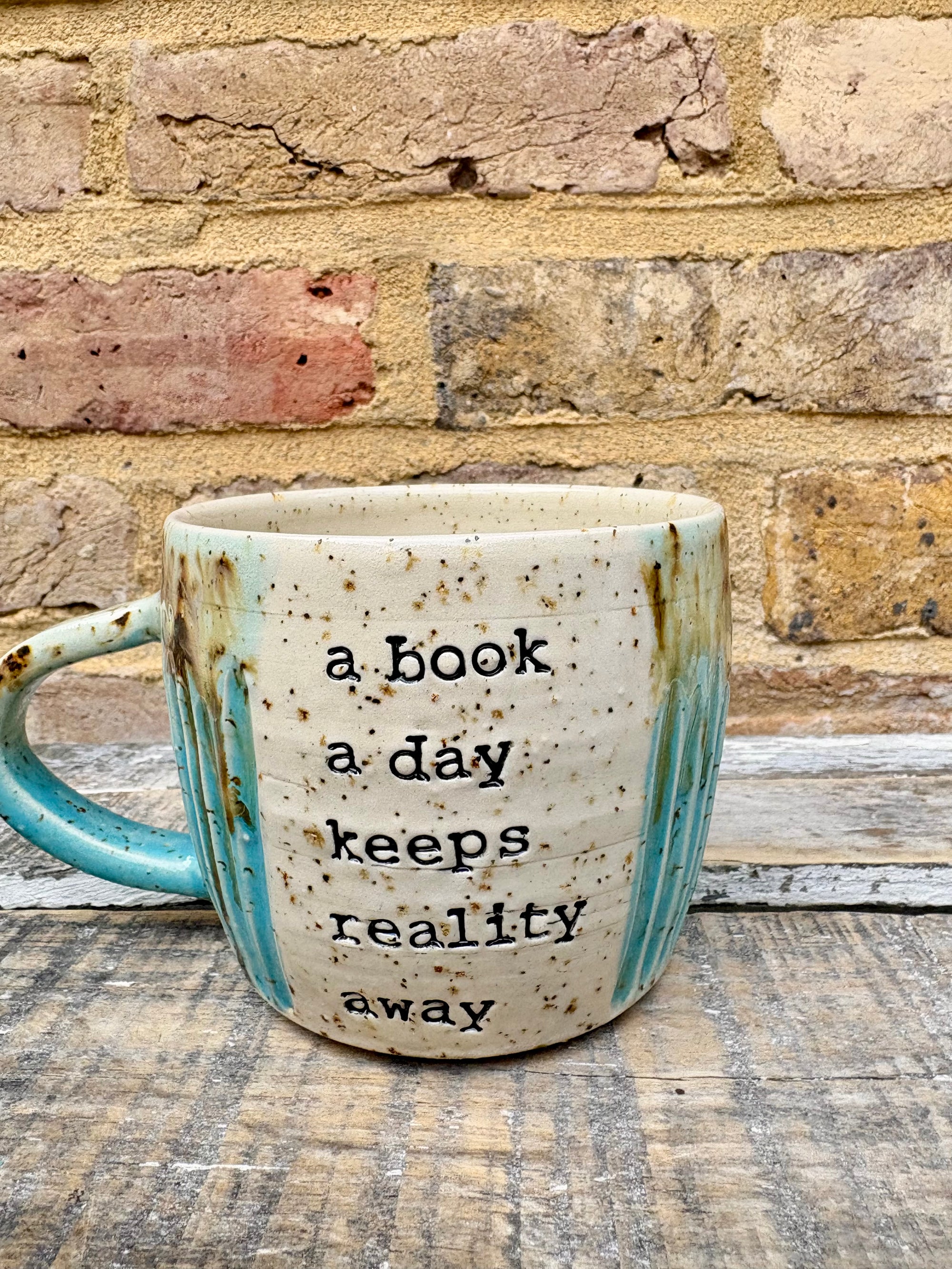 “A book a day keeps reality away" mug (turquoise)