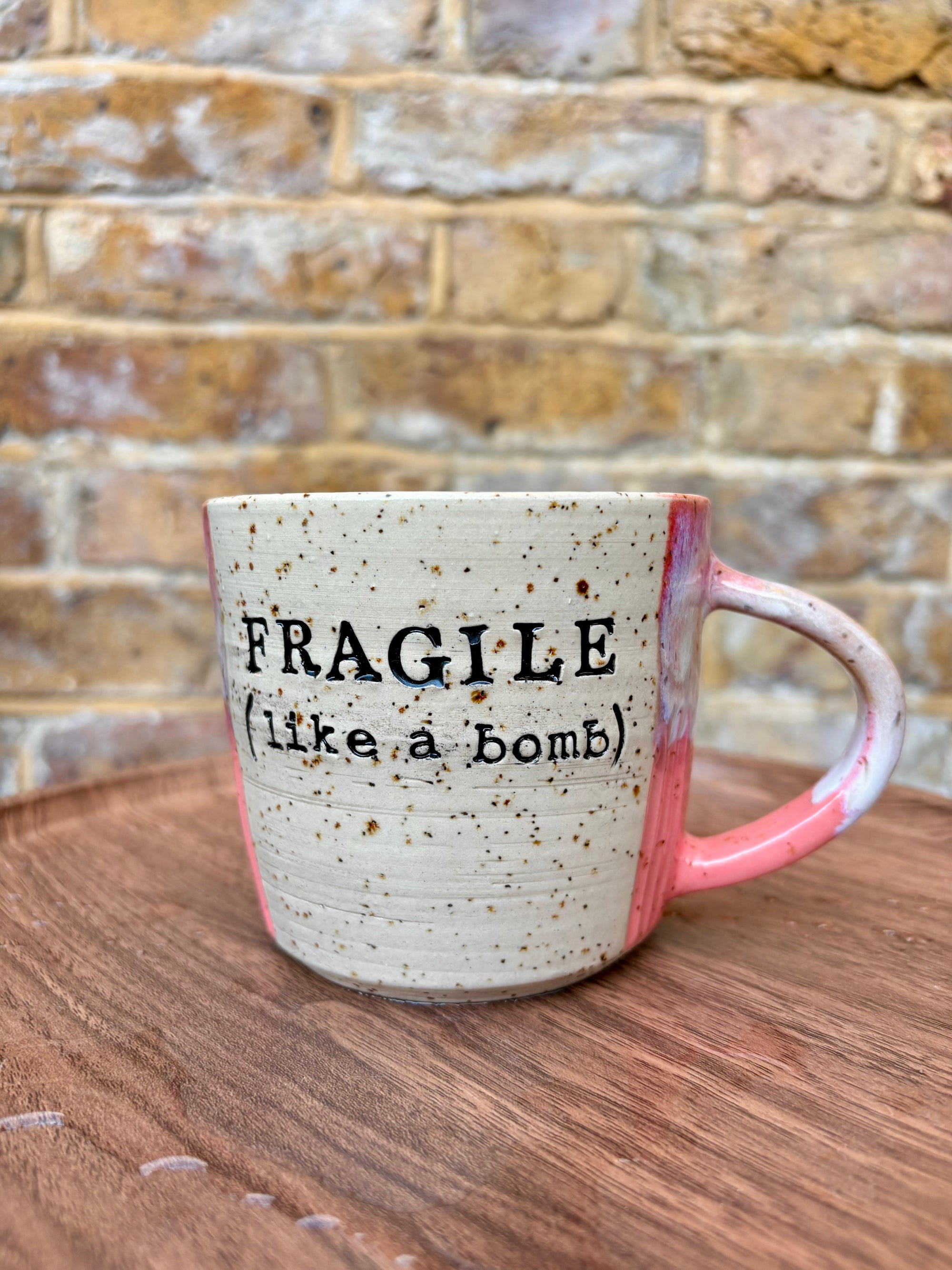 “FRAGILE (like a bomb) mug (pink, black text)