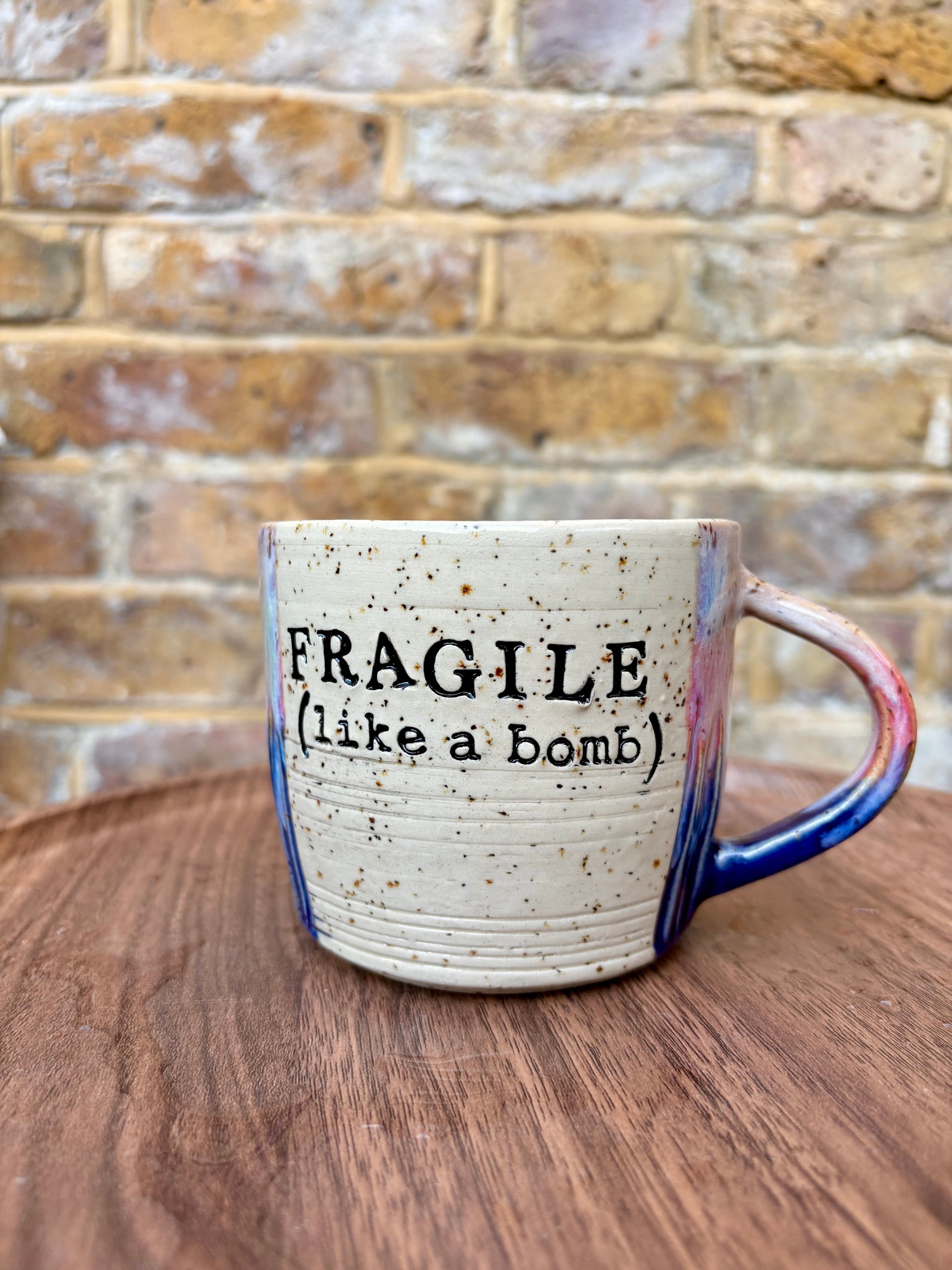 “FRAGILE (like a bomb) mug (blue/pink/black text)