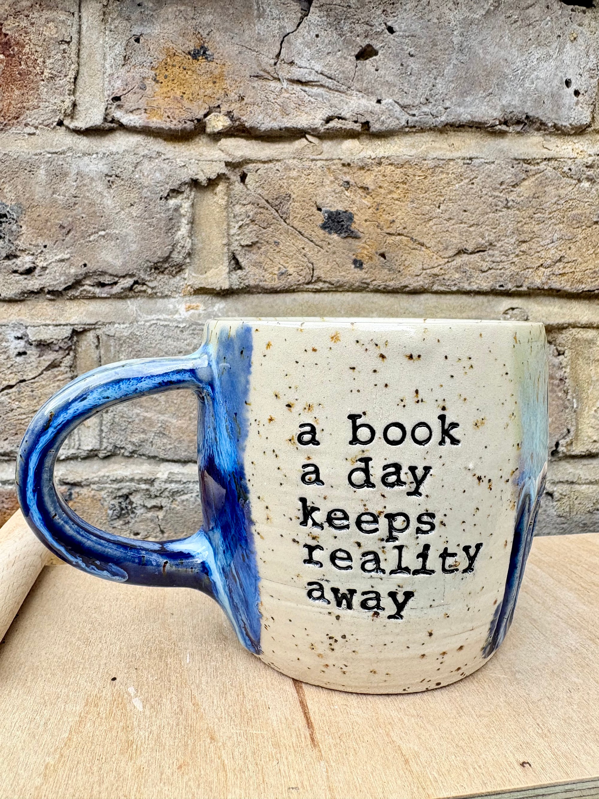 “A book a day keeps reality away" mug (blue night sky)