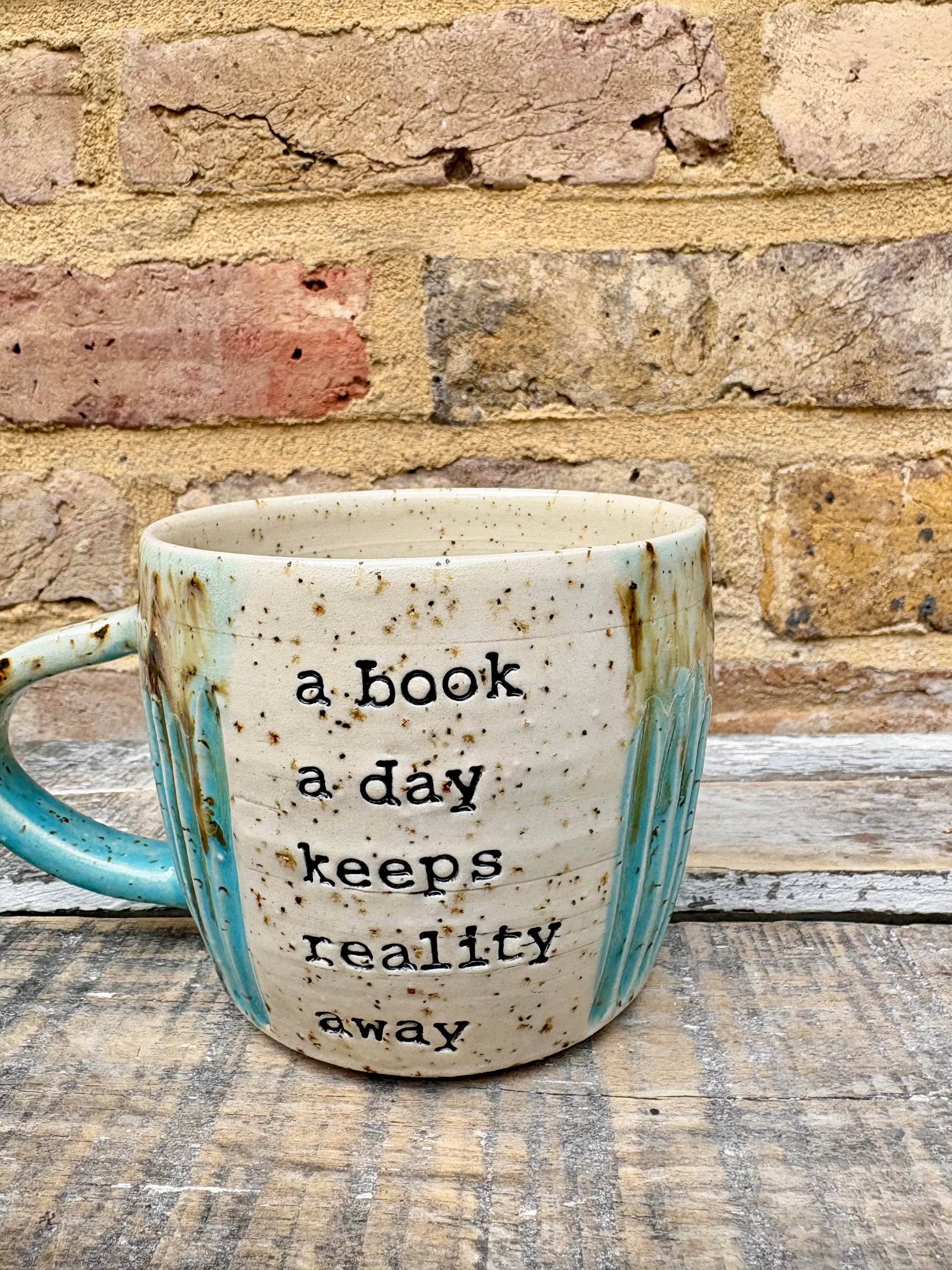 “A book a day keeps reality away" mug (turquoise)