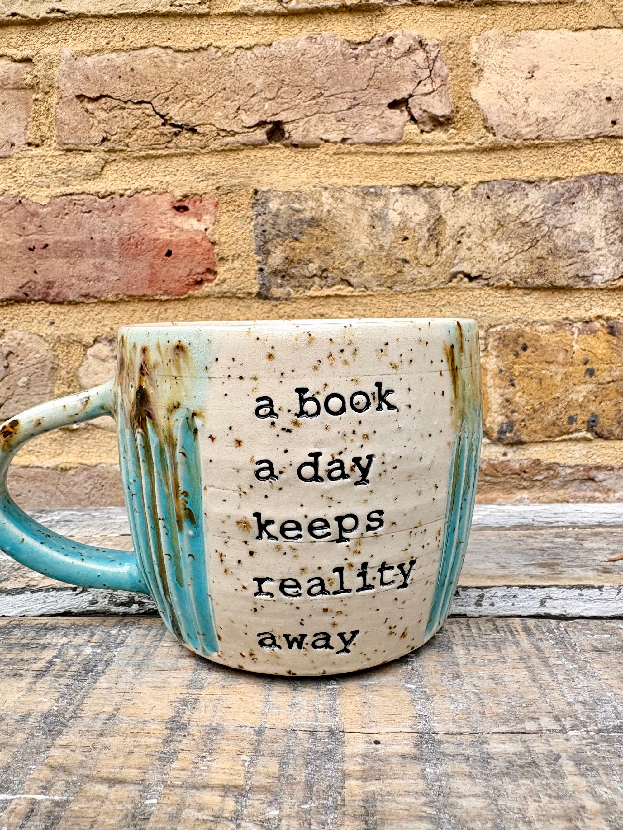 “A book a day keeps reality away" mug (turquoise)