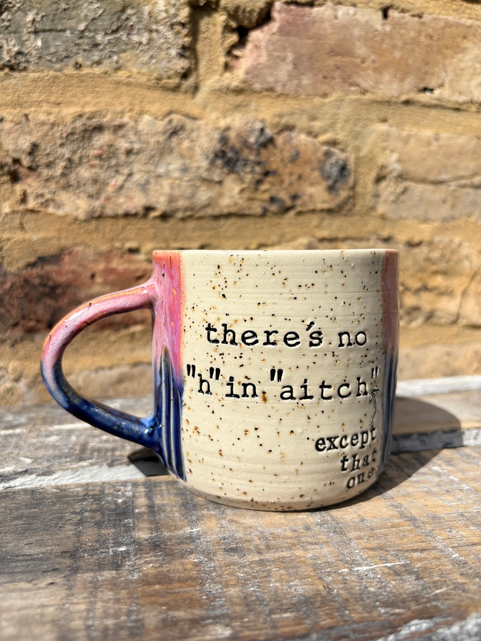 ""there's no "h" in "aitch" except that one" mug (pink/blue)
