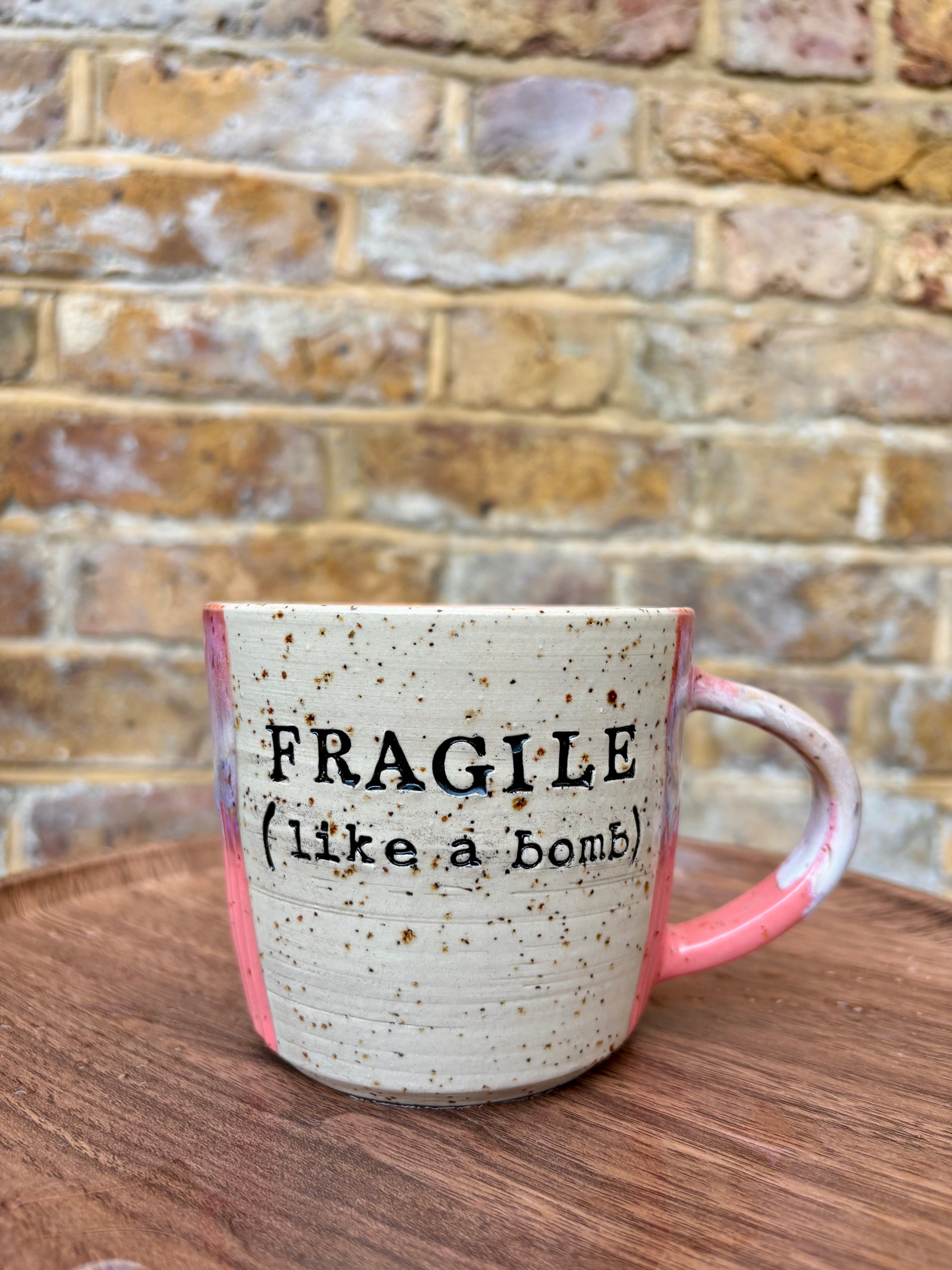 “FRAGILE (like a bomb) mug (pink, black text)