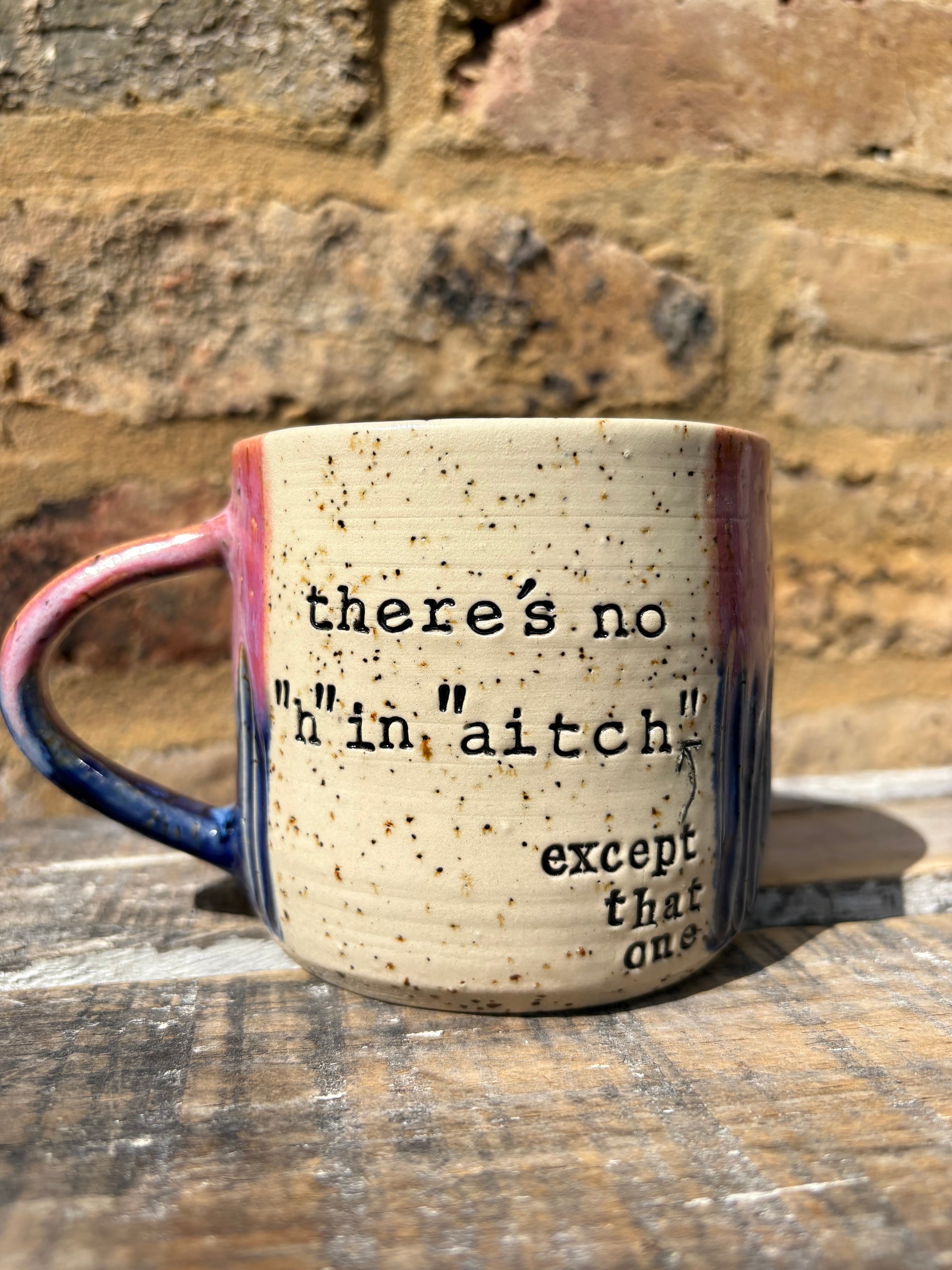 ""there's no "h" in "aitch" except that one" mug (pink/blue)