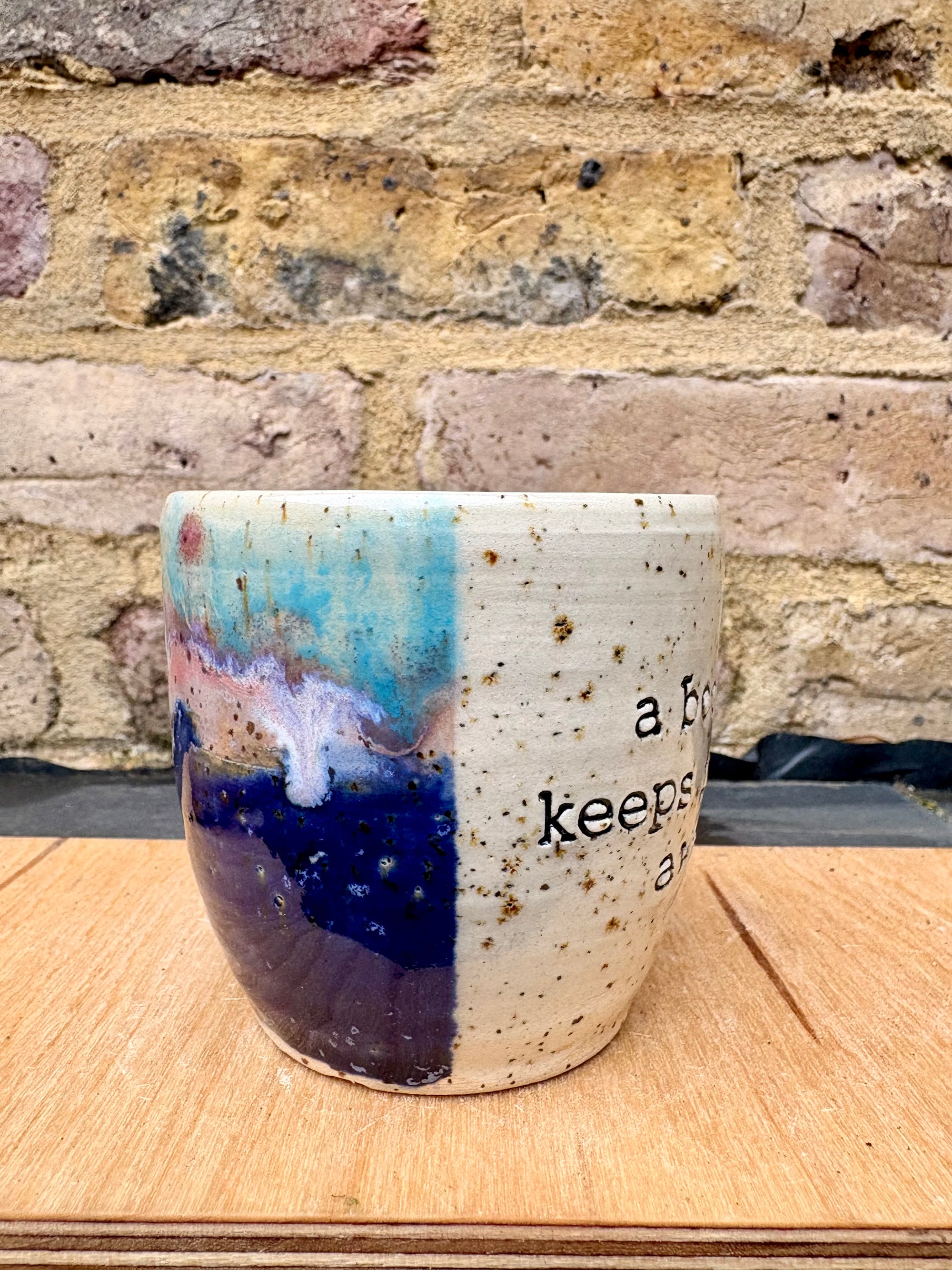 “A book a day keeps reality away" mug (blue night sky)