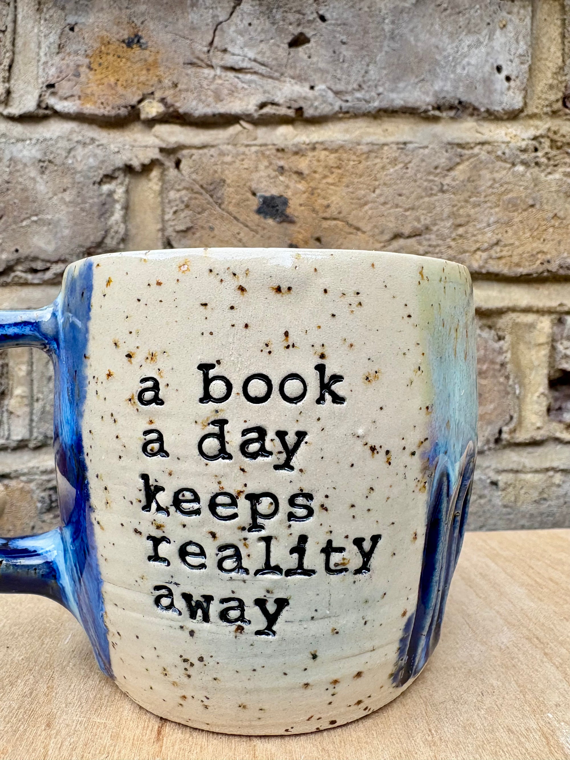 “A book a day keeps reality away" mug (blue night sky)